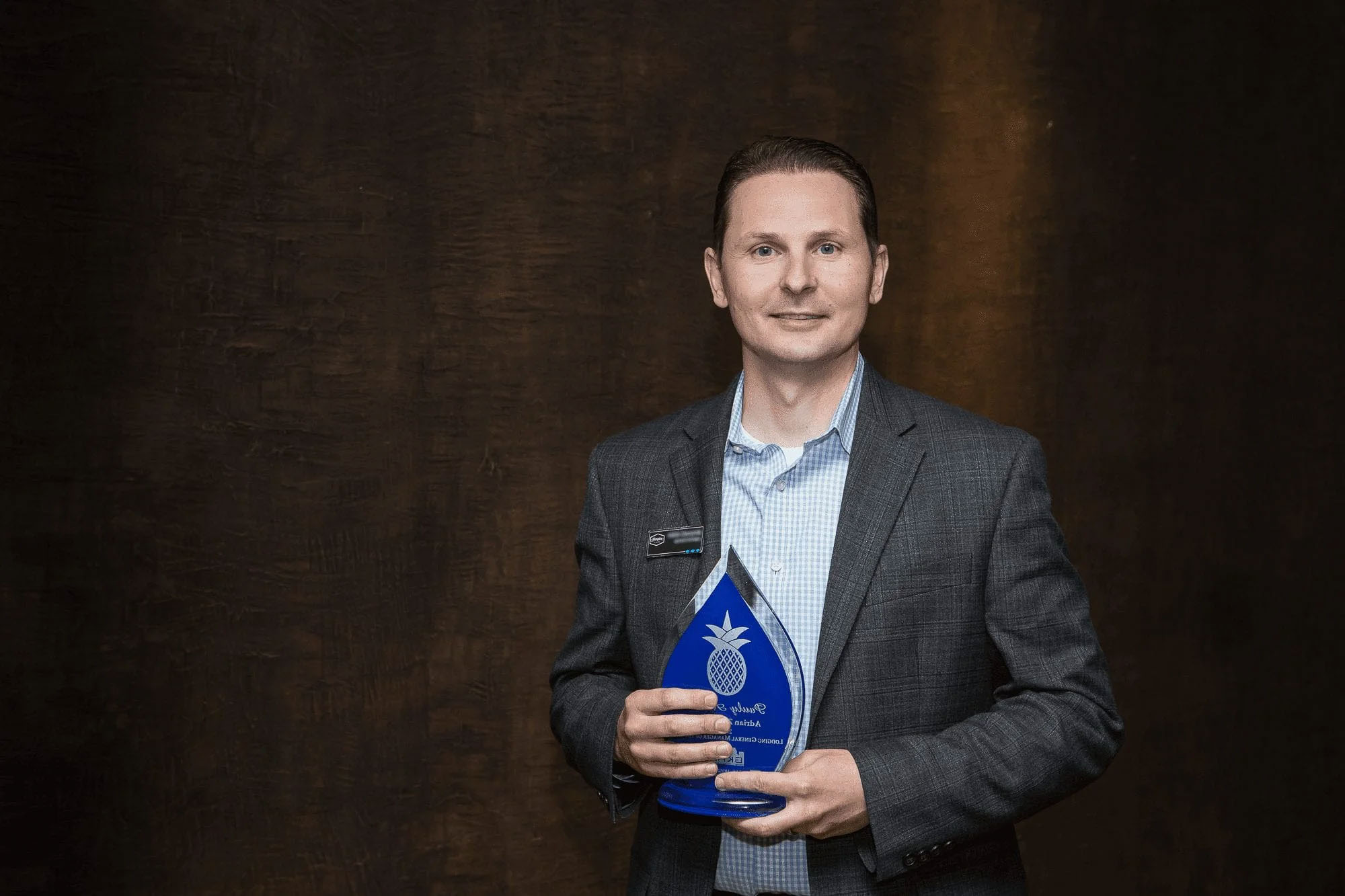 Knoxville corporate event photographer captures an award recipient holding a business achievement award.