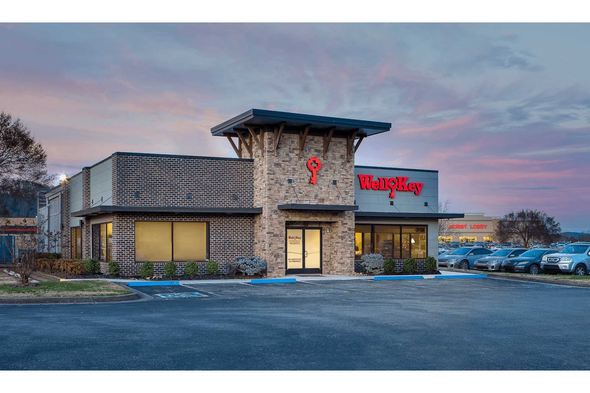 Knoxville architectural photography of the WellKey commercial building exterior at dusk with illuminated signage and stone and brick facade