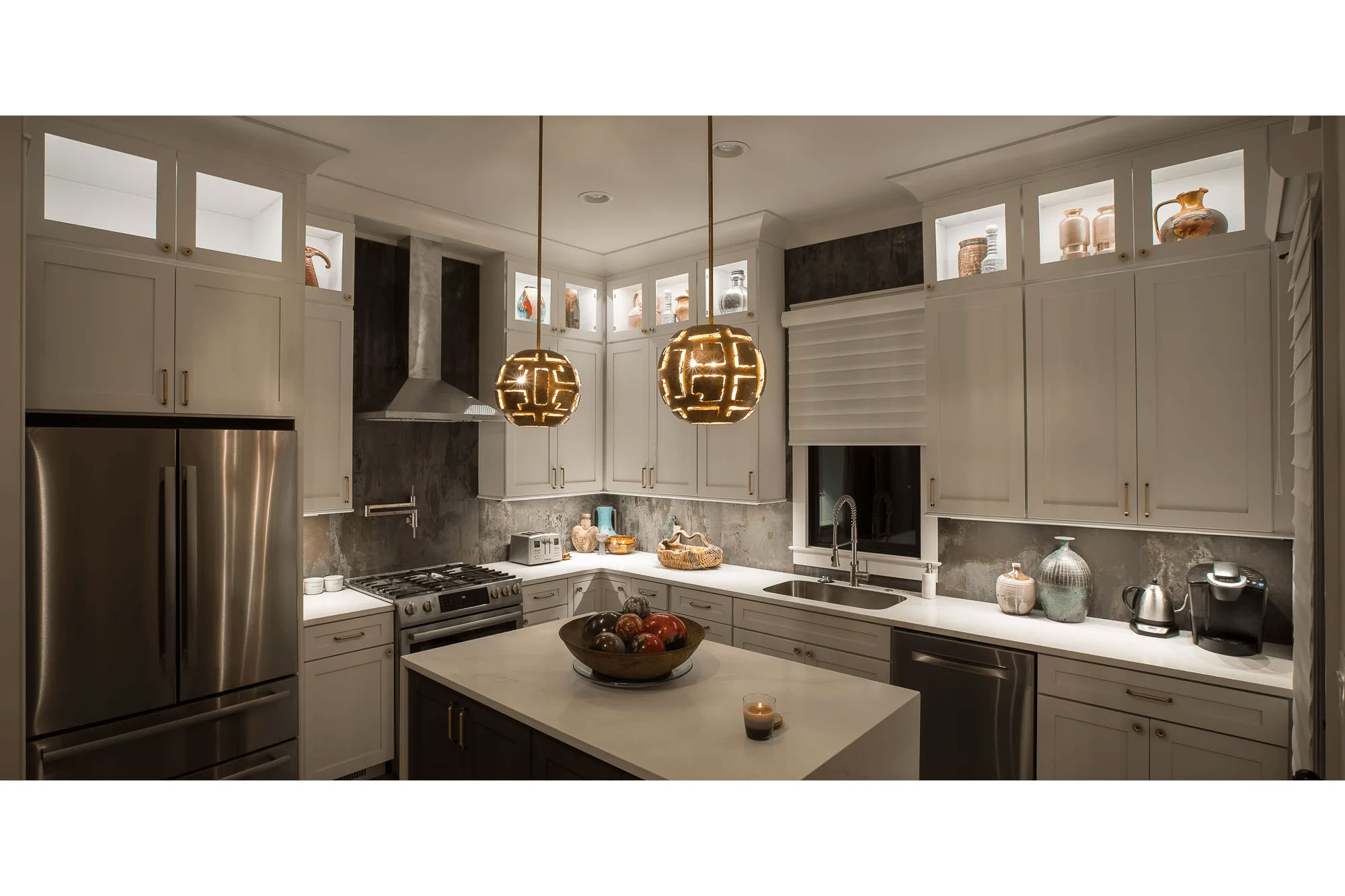 Knoxville architectural photography of a modern kitchen interior with white cabinetry, stainless steel appliances, pendant lighting, and a large island