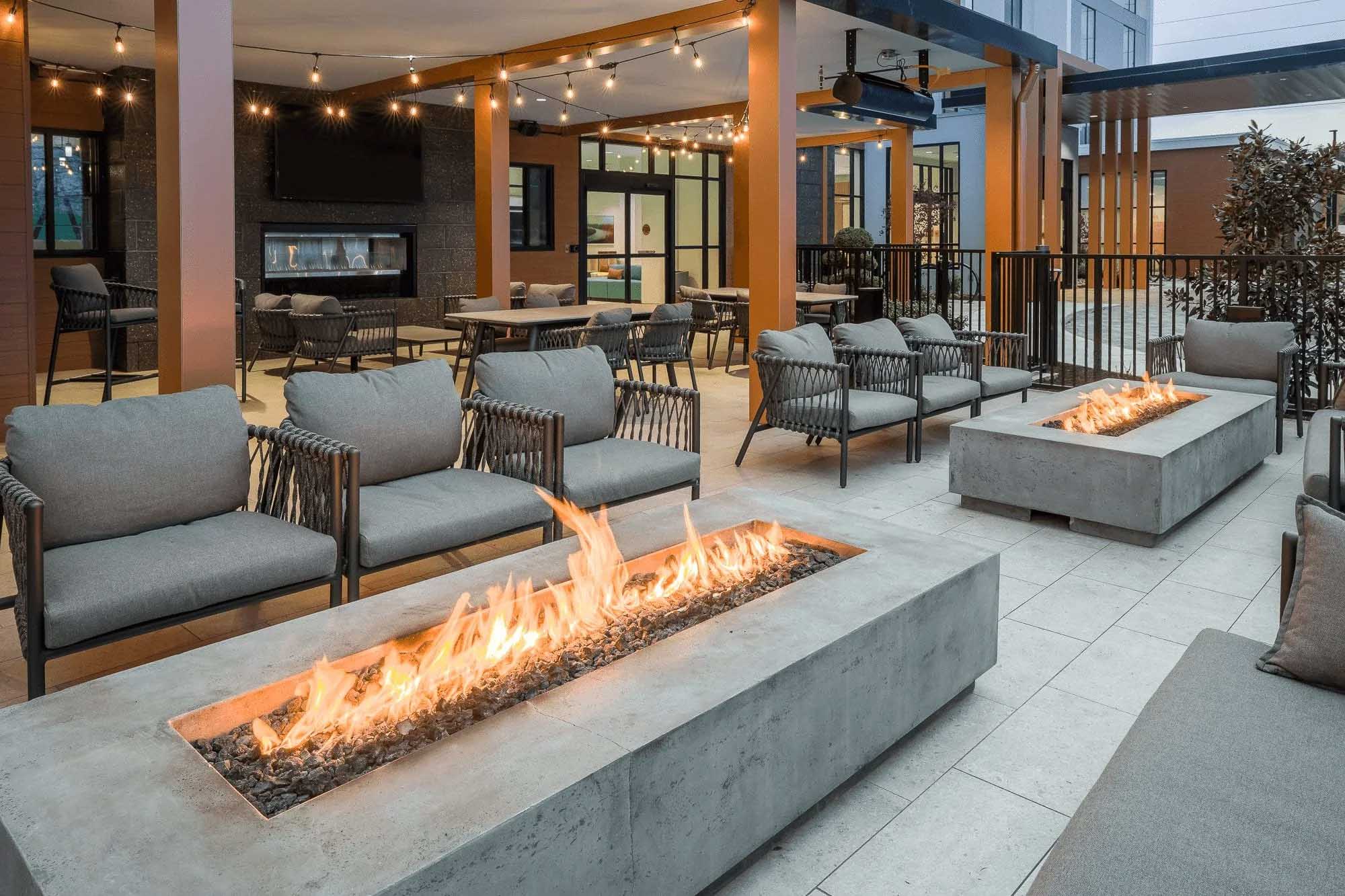 Knoxville architectural photography of a hotel outdoor patio with modern seating, concrete fire pits, string lights, and covered gathering areas