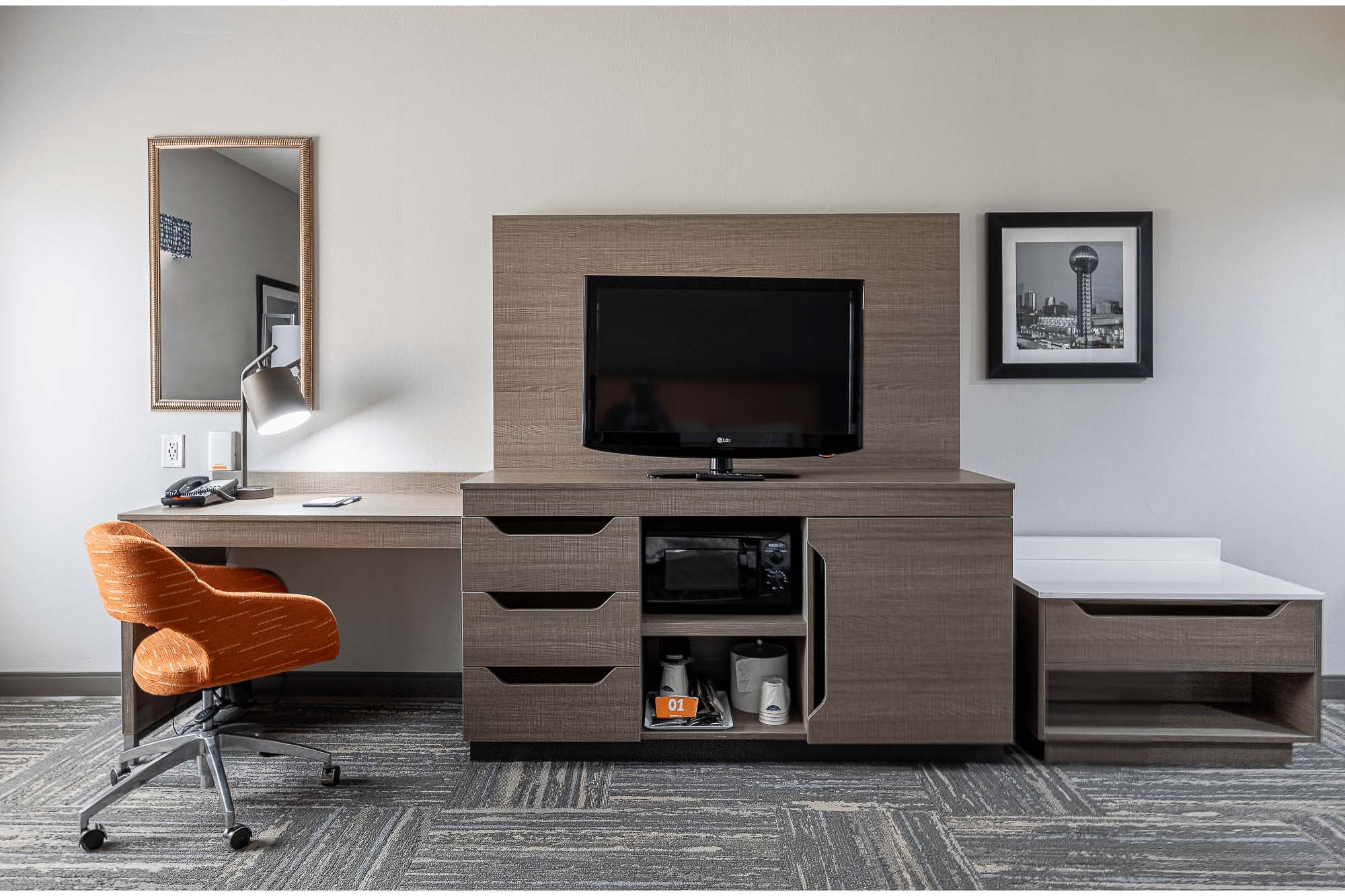 Knoxville architectural photography of a hotel guest room interior with a modern desk, television, storage cabinetry, and contemporary furnishings