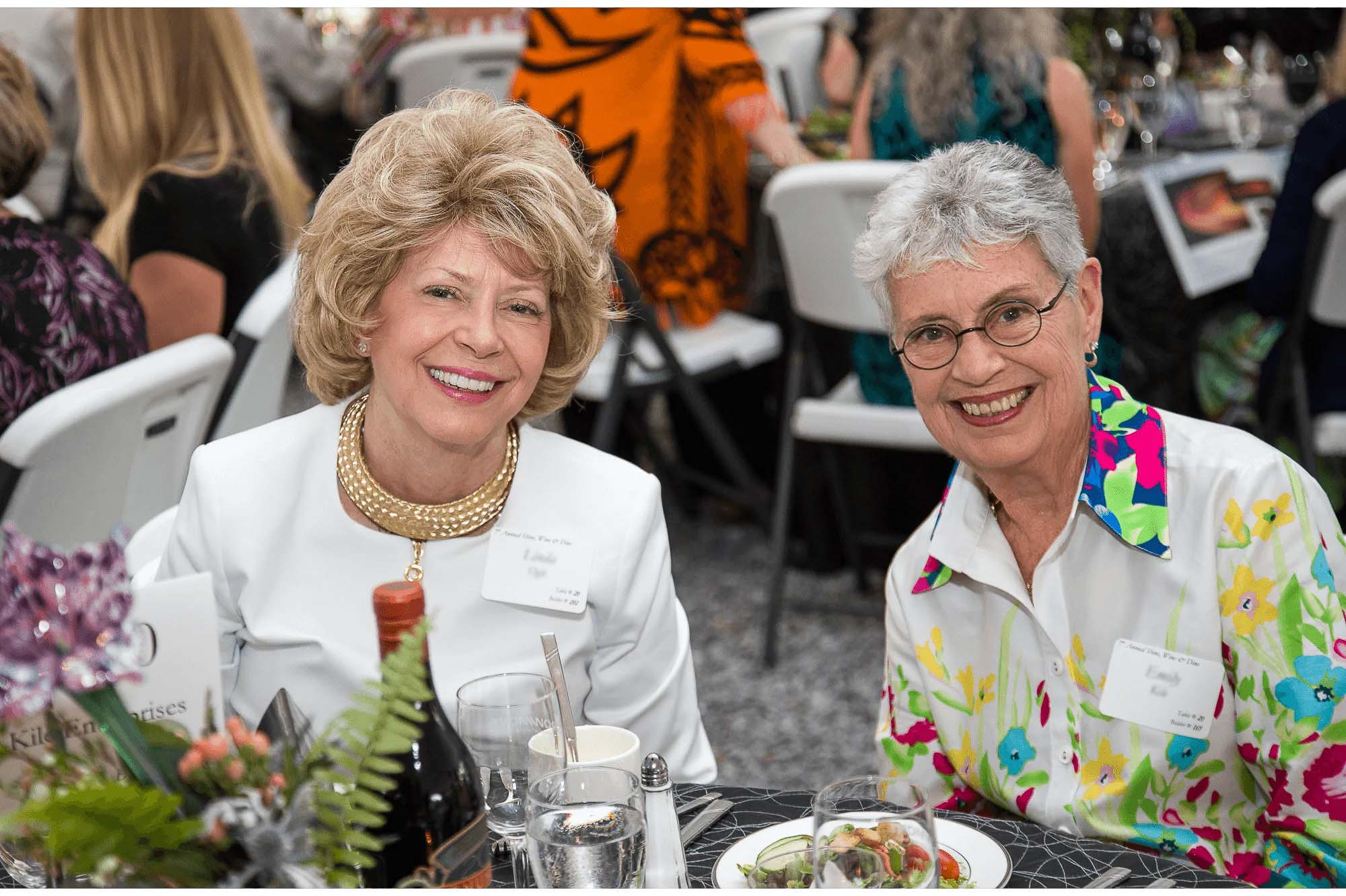 Knoxville corporate event photographer captures two guests smiling together at a business event.